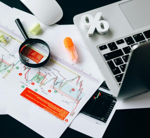 A top view of a workspace featuring financial documents, a laptop, and office supplies emphasizing data analysis.